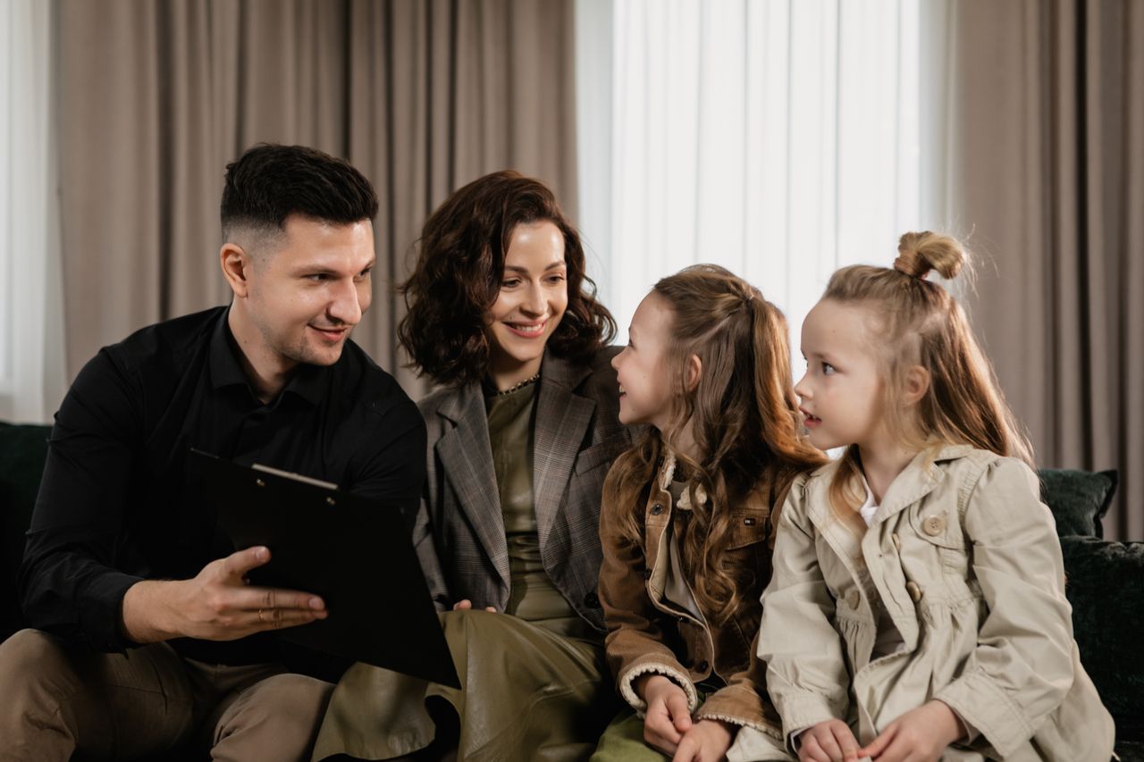 A family of four enjoying quality time together indoors, focusing on a clipboard.